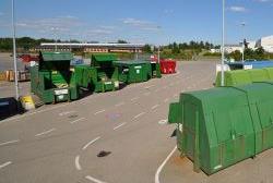 En tresporet kørebane med grønne containere på begge sider